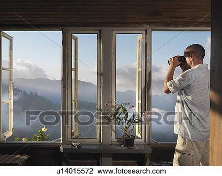 Stock Image - Man & Binoculars Inspecting Plantation. Fotosearch