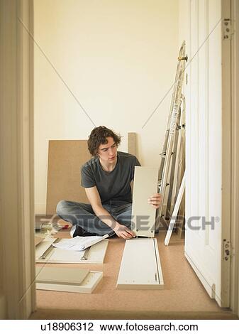 Man building flatpack furniture View Large Photo Image Stock Image - Man building flatpack furniture. Fotosearch