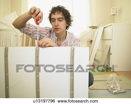 Stock Photograph - Man building furniture. Fotosearch