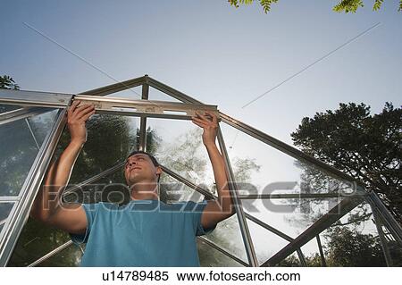 Man building greenhouse View Large Photo Image Stock Photography - Man building greenhouse. Fotosearch