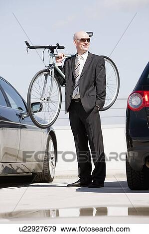 Stock Photo - man carrying bike. Fotosearch
