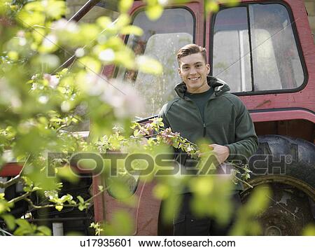 Stock Image - Man Collecting Blossom And Tractor. Fotosearch