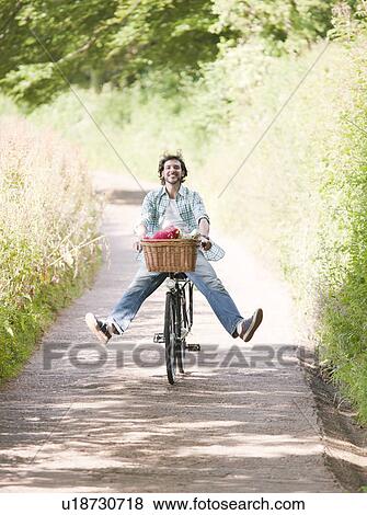 Man cycling in country lane View Large Photo Image Stock Photo - Man cycling in country lane. Fotosearch