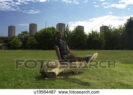 Stock Photo - man doping exercises on log in park. Fotosearch
