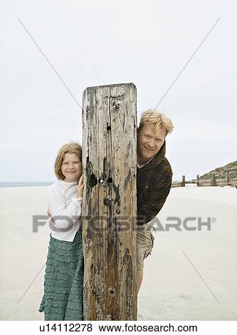 Stock Photo - Man & Girl leaning from out behind post. Fotosearch