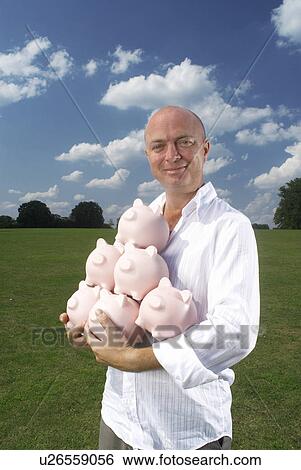 Stock Photograph - man holding piggy banks. Fotosearch