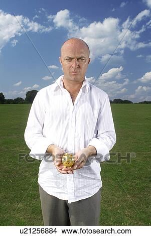 Picture - man holding small piggy bank. Fotosearch