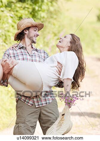 Man holding woman in his arms View Large Photo Image Stock Image - Man holding woman in his arms. Fotosearch