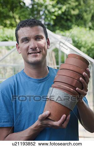 Man in garden with plant pots View Large Photo Image Stock Image - Man in garden with plant pots. Fotosearch
