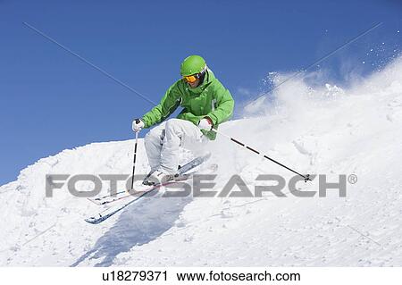 Man in green skiing off piste. View Large Photo Image Stock Image - Man in green skiing off piste.. Fotosearch