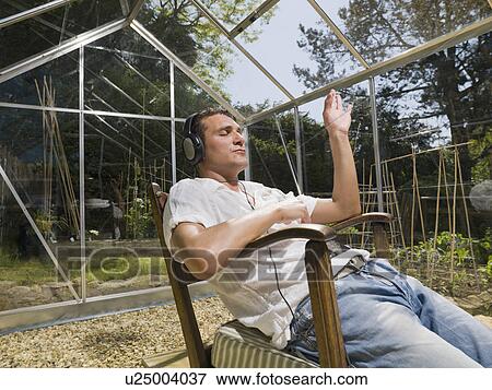Man in greenhouse with headphones View Large Photo Image Stock Photo - Man in greenhouse with headphones. Fotosearch