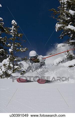 Stock Photo - Man in white & grey camo suit off-piste.. Fotosearch