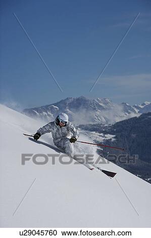 Stock Image - Man in white & grey camo suit turning.. Fotosearch