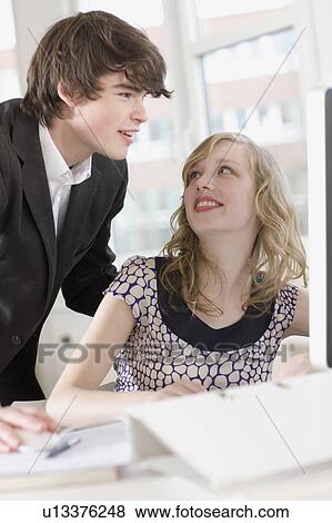 Stock Photo - man is teaching something to a woman. Fotosearch