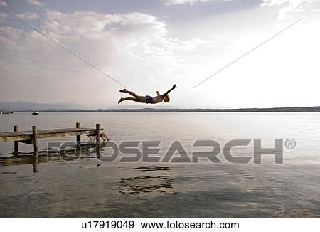 Stock Photo - man jumping from pier. Fotosearch