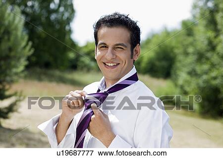 Stock Photo - man knotting tie. Fotosearch