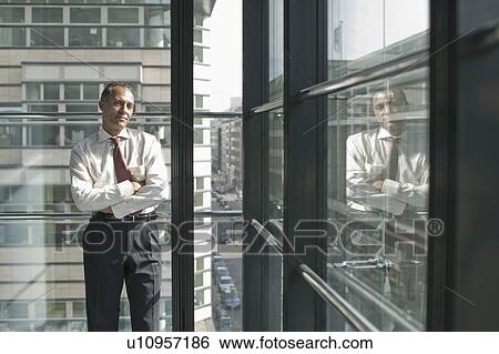 Stock Photograph - man leaning at window smiling. Fotosearch