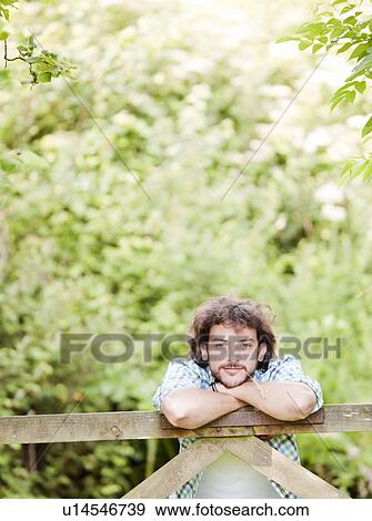 Man leaning on countryside gate View Large Photo Image Stock Photo - Man leaning on countryside gate. Fotosearch