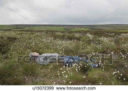 Man lying in field on moors View Large Photo Image Stock Photo - Man lying in field on moors. Fotosearch