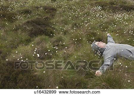Stock Photo - Man lying in field. Fotosearch