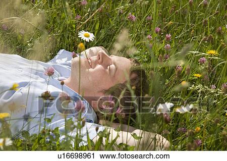 man lying in grass with spring flowers View Large Photo Image Stock Image - man lying in grass with spring flowers. Fotosearch