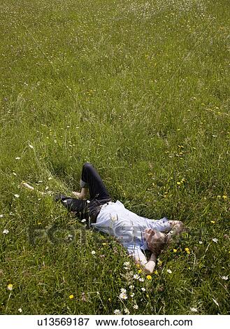 man lying in grass with spring flowers View Large Photo Image Stock Photo - man lying in grass with spring flowers. Fotosearch