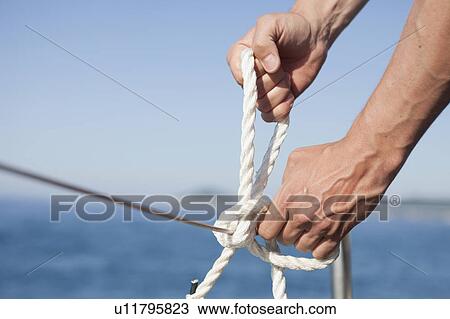 man making knot into rope View Large Photo Image Stock Image - man making knot into rope. Fotosearch