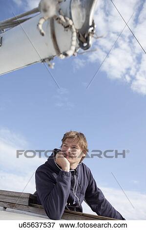 Stock Photo - Man on a boat looking at the sea. Fotosearch