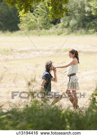 Stock Photograph - man on knees kissing womans hand. Fotosearch