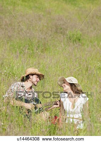 Stock Photo - man playing guitar to woman. Fotosearch