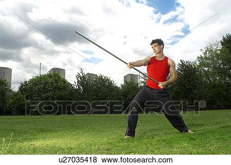 Stock Photo - man posing with bow staff. Fotosearch