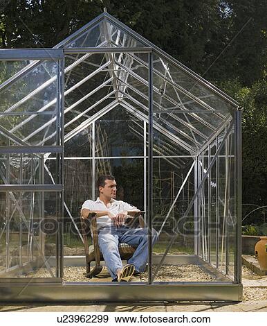 Stock Photo - Man relaxing in greenhouse. Fotosearch