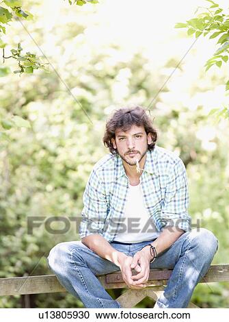 Man sat on countryside gate View Large Photo Image Stock Image - Man sat on countryside gate. Fotosearch