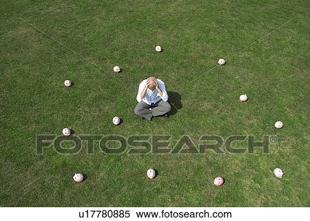 man sitting amongst piggy banks View Large Photo Image Stock Photography - man sitting amongst piggy banks. Fotosearch