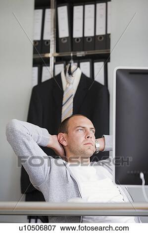 Stock Photo - man sitting at desk thinking. Fotosearch