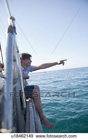 man sitting at the rail of a boat View Large Photo Image Stock Photo - man sitting at the rail of a boat. Fotosearch