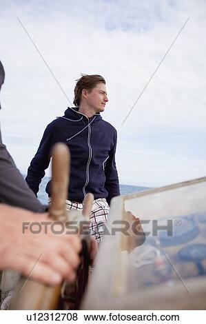 Man sitting next to a steering wheel View Large Photo Image Stock Photo - Man sitting next to a steering wheel. Fotosearch