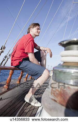 Man sitting on a wooden rail View Large Photo Image Stock Image - Man sitting on a wooden rail. Fotosearch