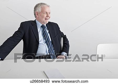 man sitting, smiling at desk View Large Photo Image Stock Image - man sitting, smiling at desk. Fotosearch