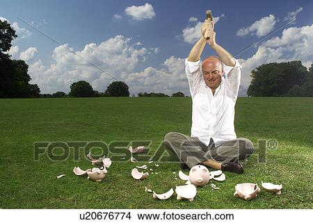 man smashing piggy banks View Large Photo Image Picture - man smashing piggy banks. Fotosearch