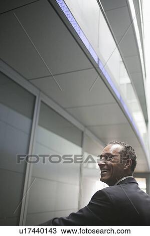 Stock Image - man smiling over his shoulder. Fotosearch