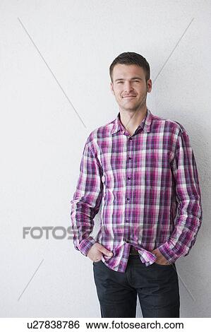 Stock Photograph - man standing in front of white wall. Fotosearch