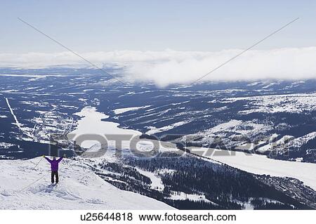Man standing on cliff edge arms raised. View Large Photo Image Stock Photo - Man standing on cliff edge arms raised.. Fotosearch