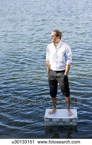 man standing on floating suitcase View Large Photo Image Stock Image - man standing on floating suitcase. Fotosearch