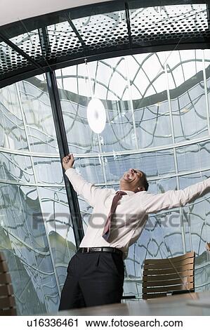 Stock Image - man stretching arms laughing upwards. Fotosearch