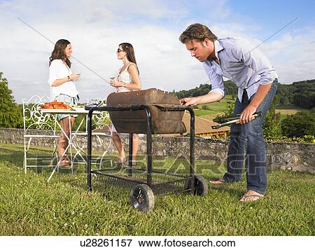 man tending barbecue View Large Photo Image Stock Photo - man tending barbecue. Fotosearch