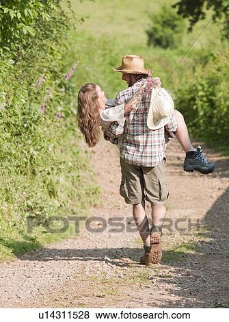 Man walking with woman in his arms View Large Photo Image Stock Photo - Man walking with woman in his arms. Fotosearch