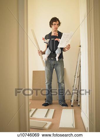 Man with baby building furniture View Large Photo Image Stock Photo - Man with baby building furniture. Fotosearch