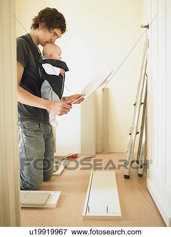 Man with baby building furniture View Large Photo Image Stock Photo - Man with baby building furniture. Fotosearch