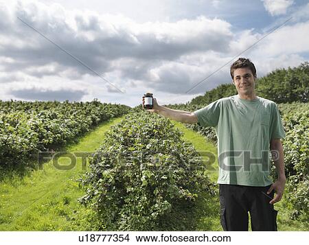 Picture - Man With Blackcurrant Jam In Field. Fotosearch